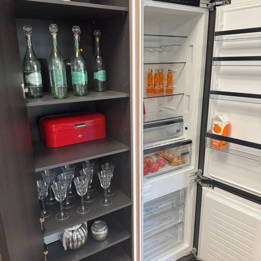 Nolte NEO Ausstellungsküche: geöffneter Regalhochschrank und Einbaukühlschrank in Korpusfarbe Lava